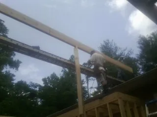 Carpenter setting a ridge beam over a new addition frame — Ice Dam Removal by Roofing Brothers in Alum Bank