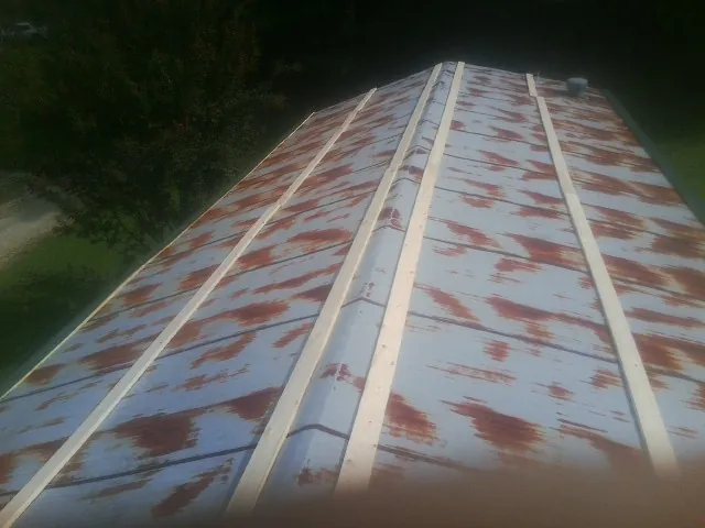 Rusted metal roof panels with new wood purlins before replacement — Storm Damage Roof Repair in Alum Bank by Roofing Brothers