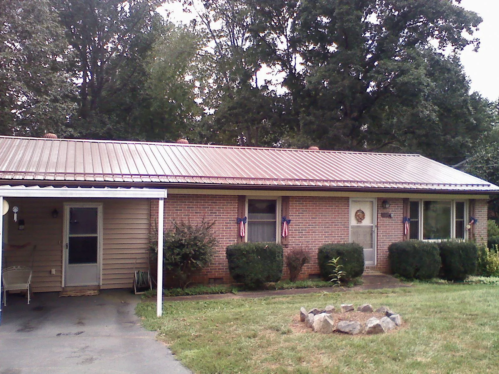 Bronze metal roof and carport on a brick ranch home — Roof Repair work by our crew in Alum Bank